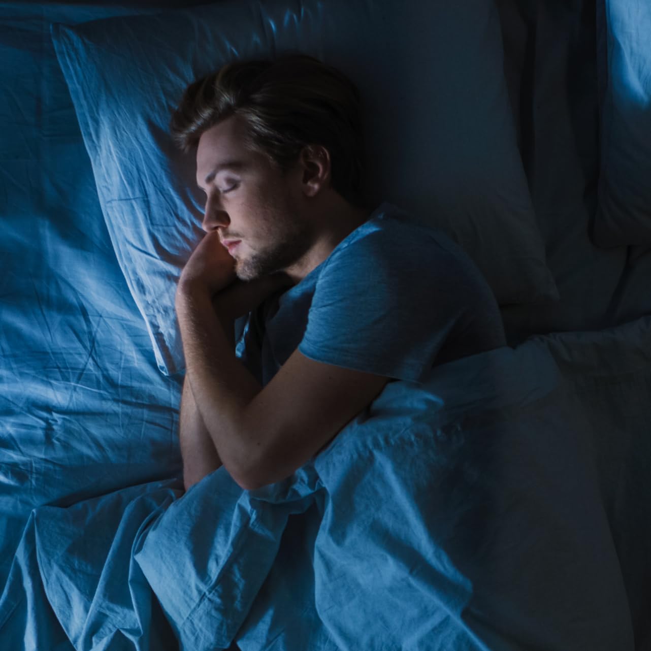 Nighttime scene with a glass of water beside the capsules.