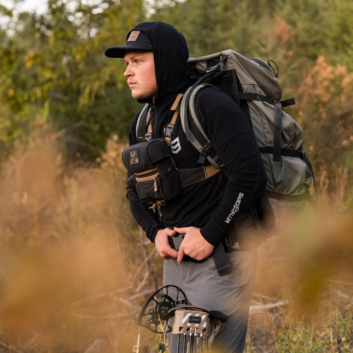 MTN OPS Venture Bar Peanut Butter Crunch in backpack scene, highlighting portable, gluten-free energy on trails.