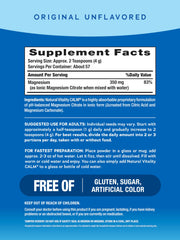 Scoop of Natural Vitality Original Calm magnesium powder next to a glass for easy hydration.