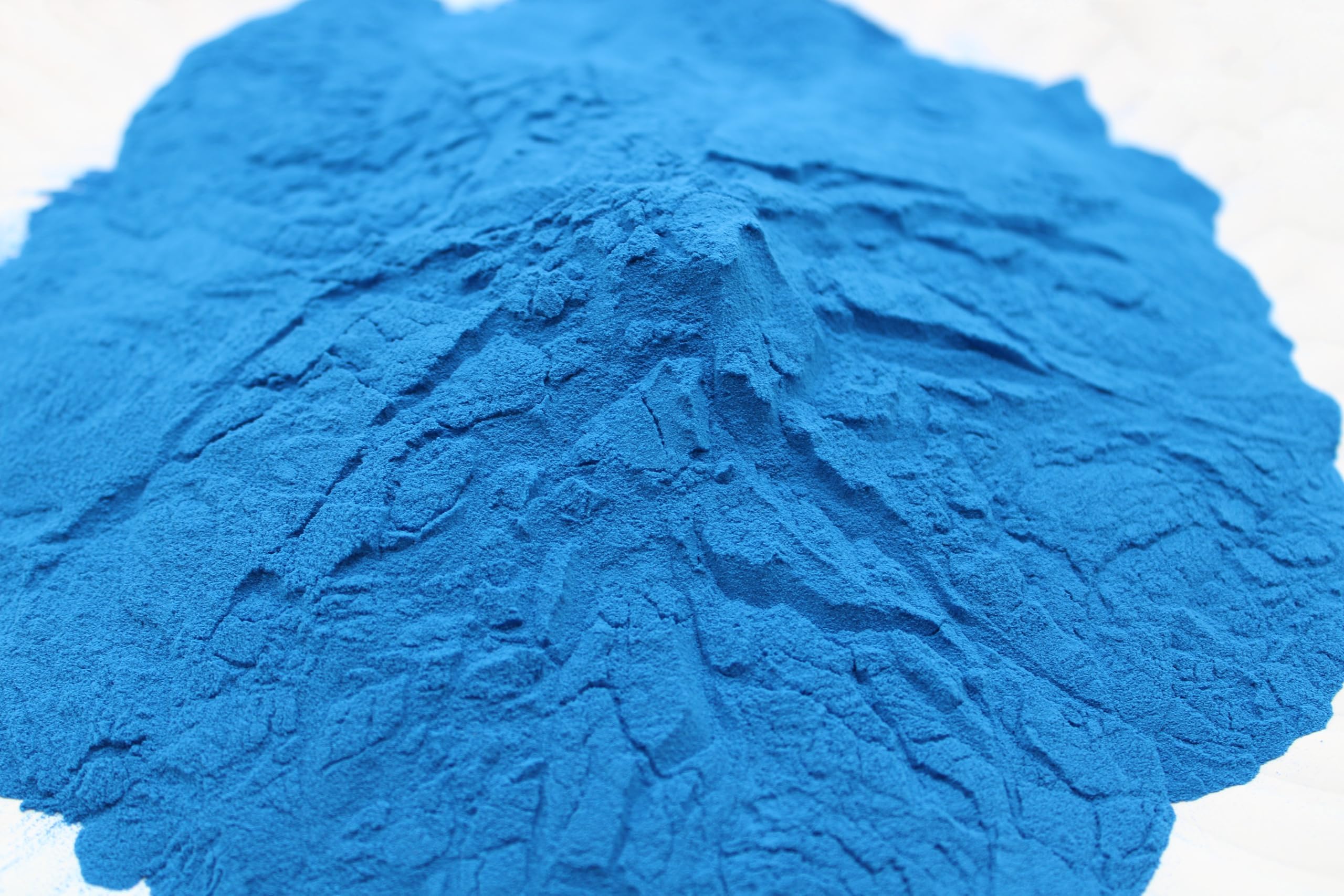 Naturejam Blue Spirulina powder on dessert plate with bright hue.