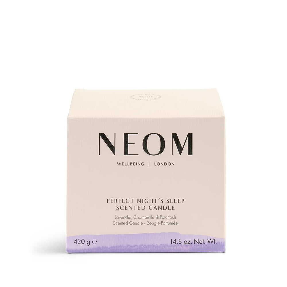 Candle lit in a cozy bedroom creates calming pre-bed ambiance with NEOM
