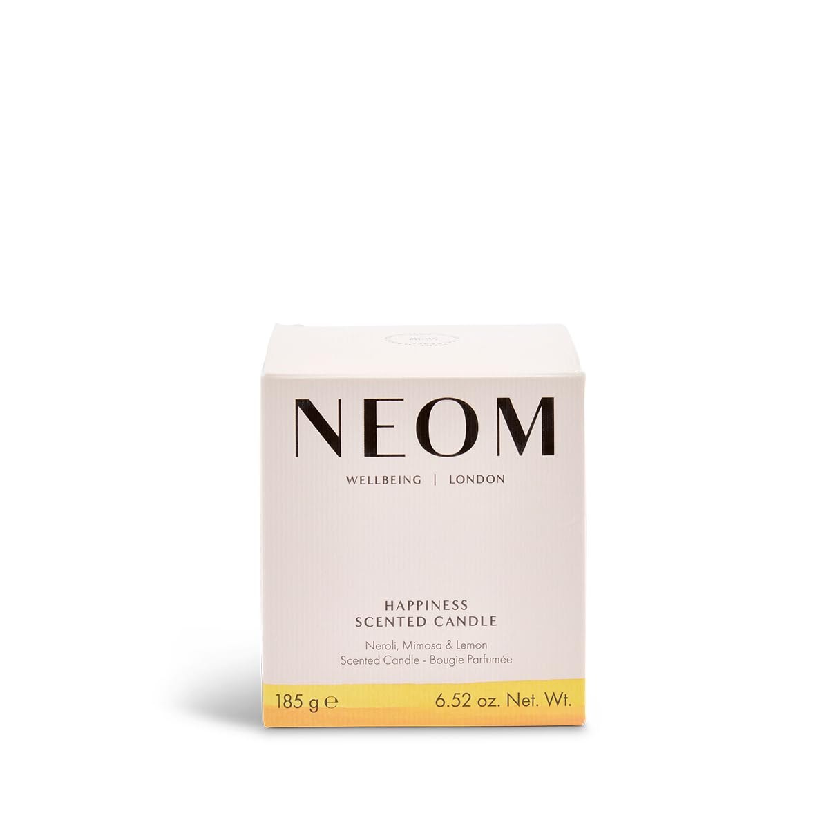 NEOM Happiness candle glowing in a cozy living room setting.