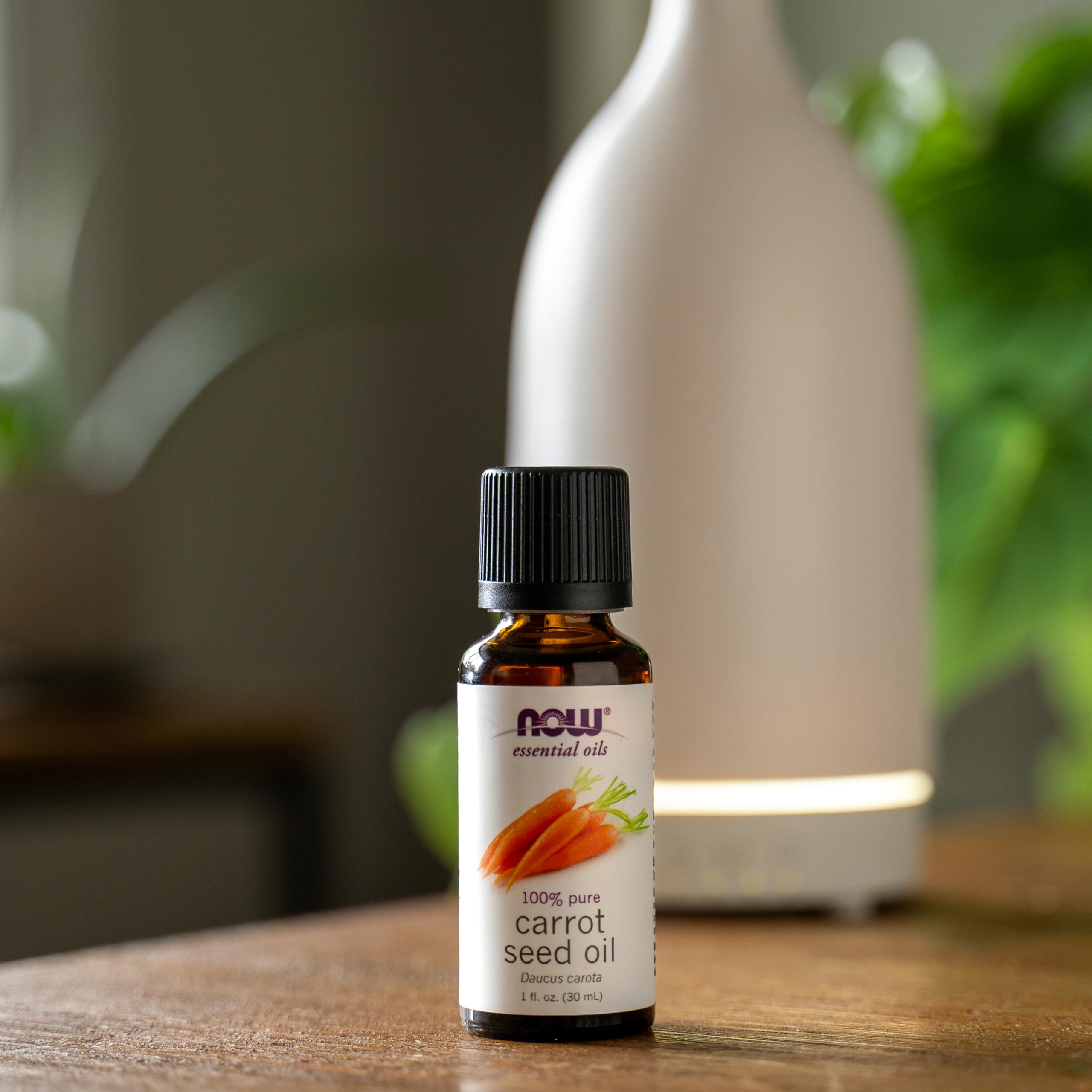 NOW Foods carrot seed oil label on bottle signaling vegan, cruelty-free origins