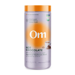 OM Mushroom Superfood hot chocolate canister logo visible for convenient daily wellness ritual.