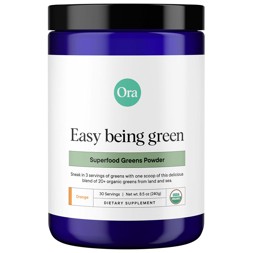 Ora Organic Greens Powder bottle on counter with citrus flavor for daily nutrition.