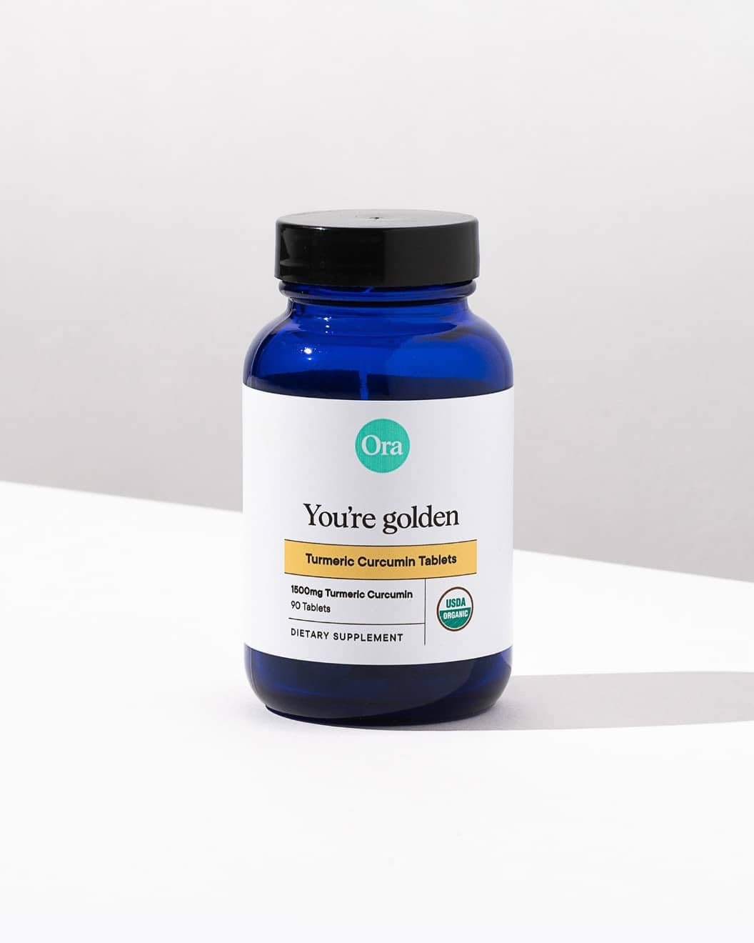 Ora Organic Turmeric Curcumin bottle bathed in natural light for premium feel.