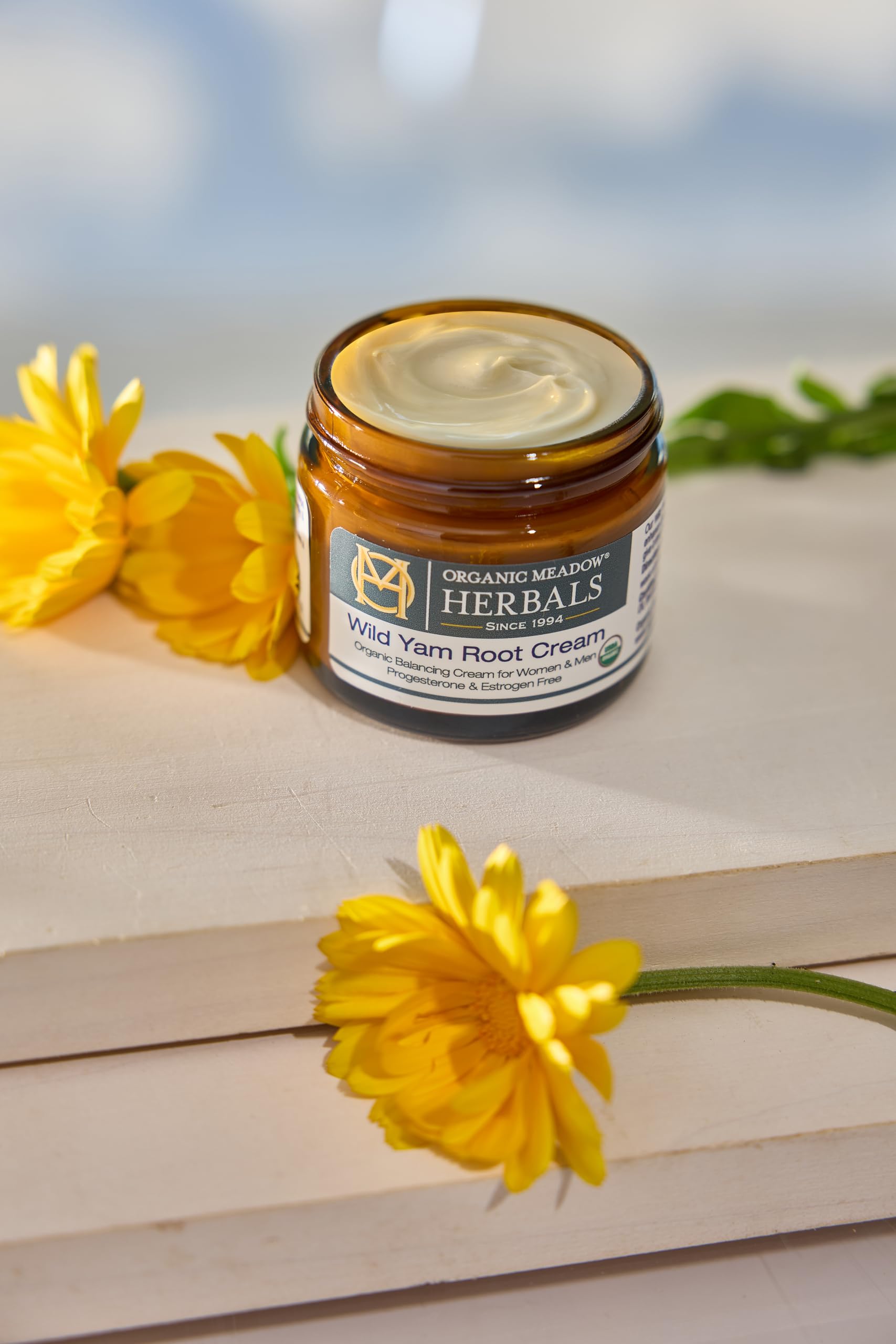 Hands applying Organic Meadow Herbals Wild Yam Root Cream for PMS-friendly soothing touch