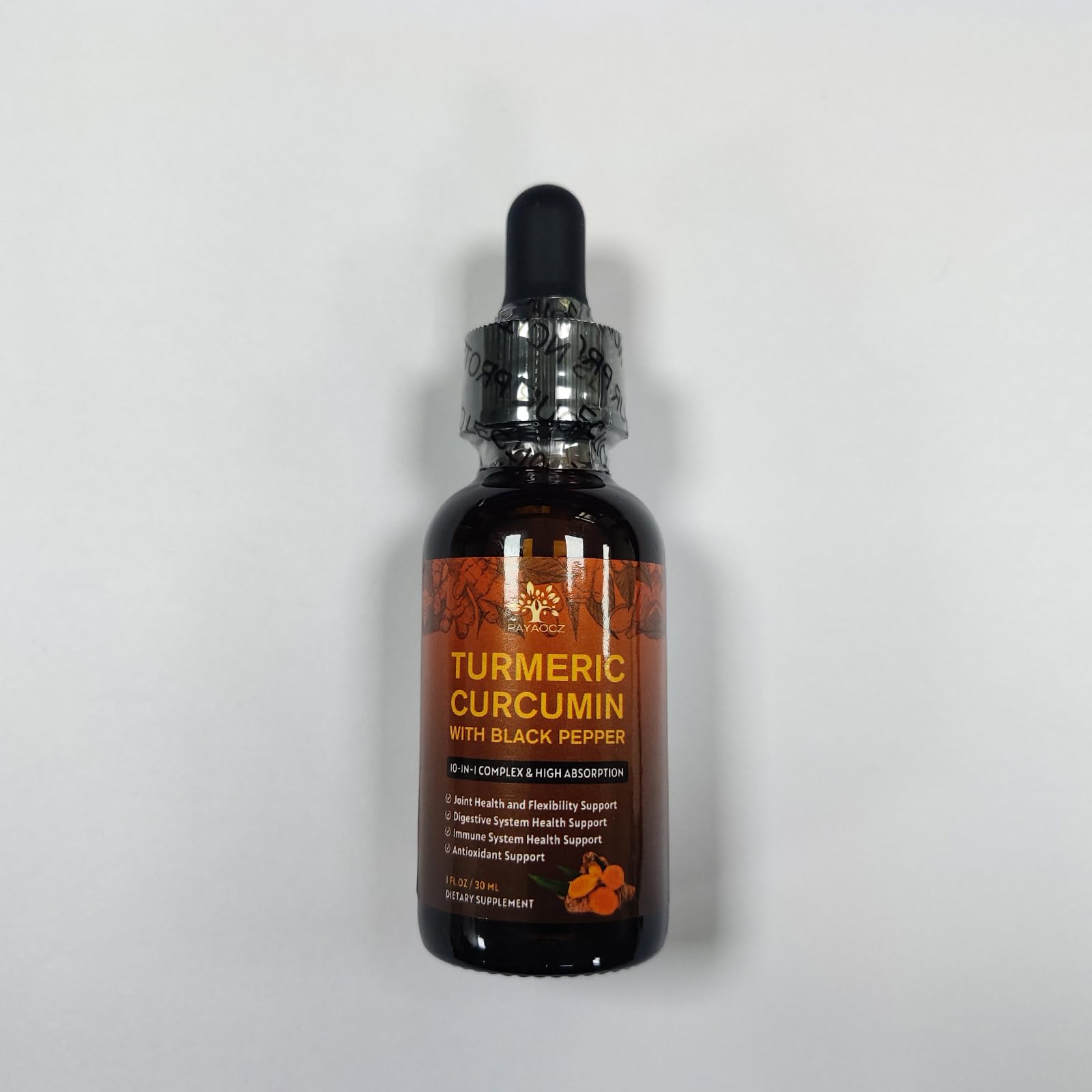 PAYAOCZ turmeric drops beside sliced ginger and turmeric roots.