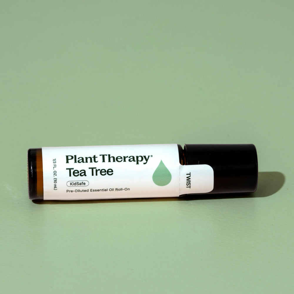 Plant Therapy Tea Tree Roll-On in hand for discreet, portable use.