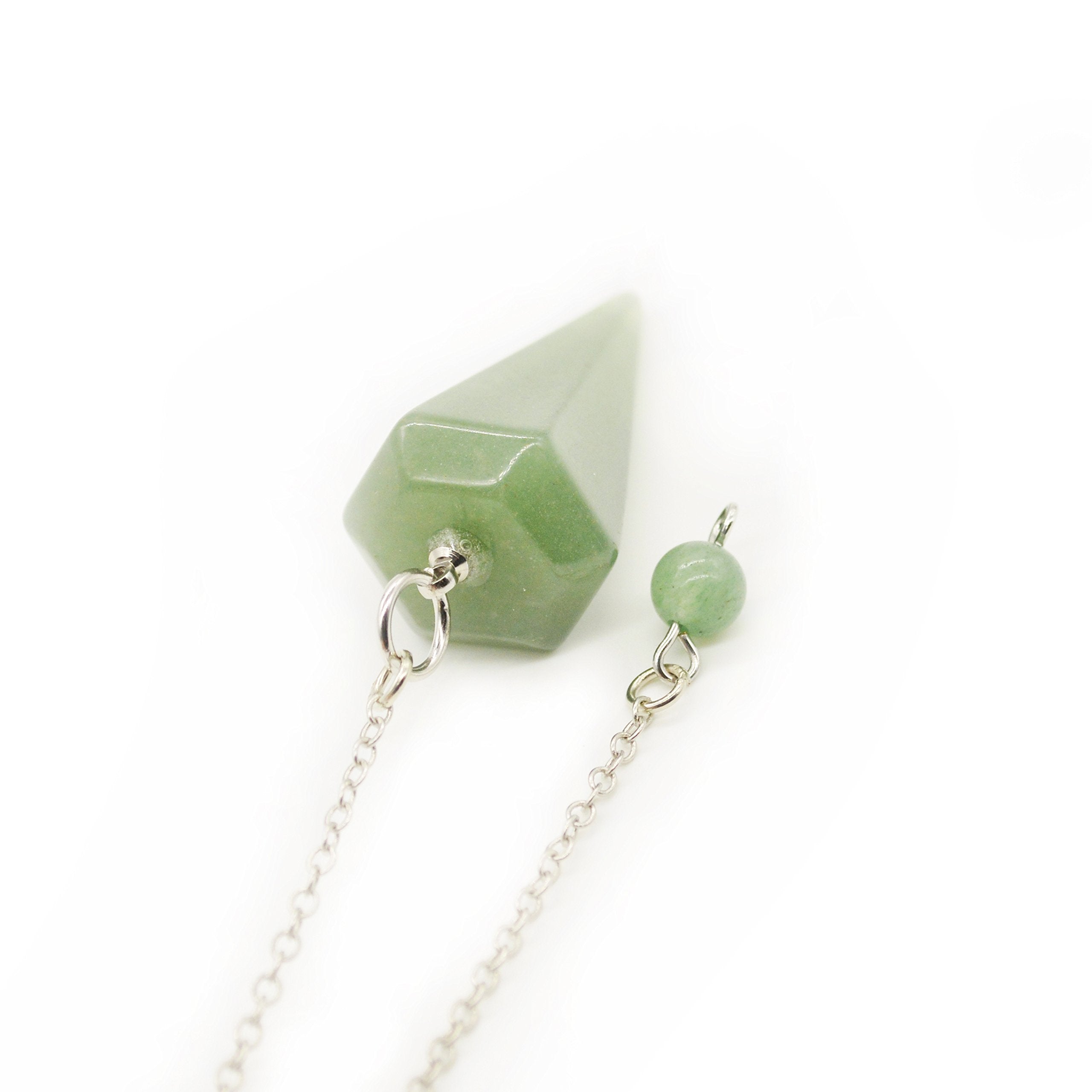 Polar Jade pendulum held in hand for personal readings and guidance.