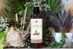 Positive Essence sandalwood massage oil label highlights natural ingredients and quality.