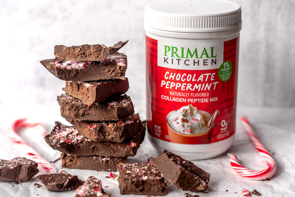 Primal Kitchen collagen powder scoop beside festive mug ready for hot chocolate.