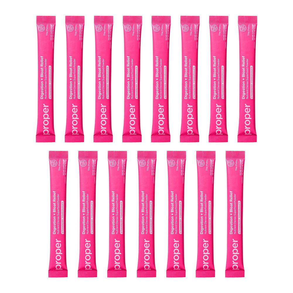 Proper Pinks powder scoop next to a glass, highlighting easy daily intake.