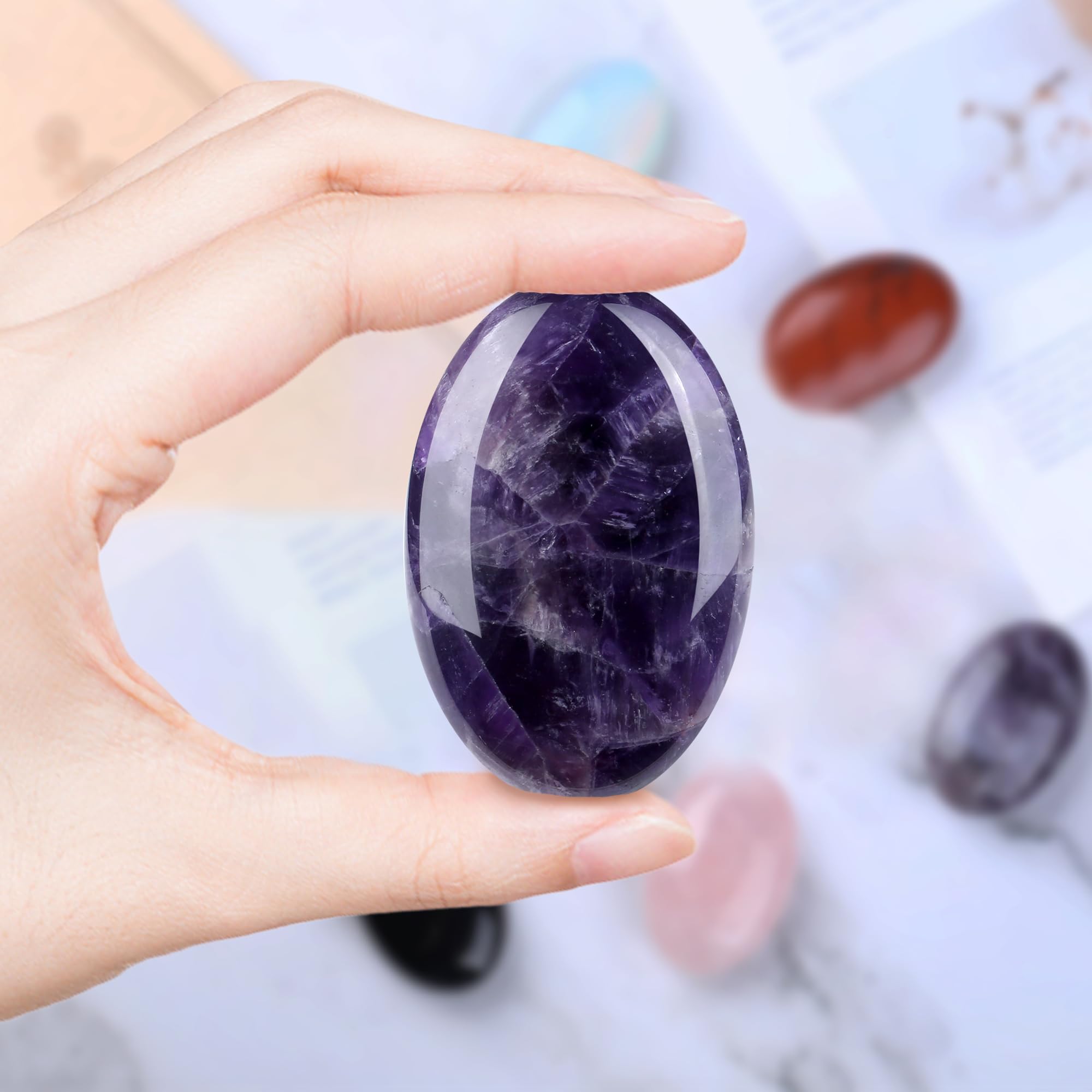 QINJIEJIE amethyst palm stone in hand for stress relief on the go.