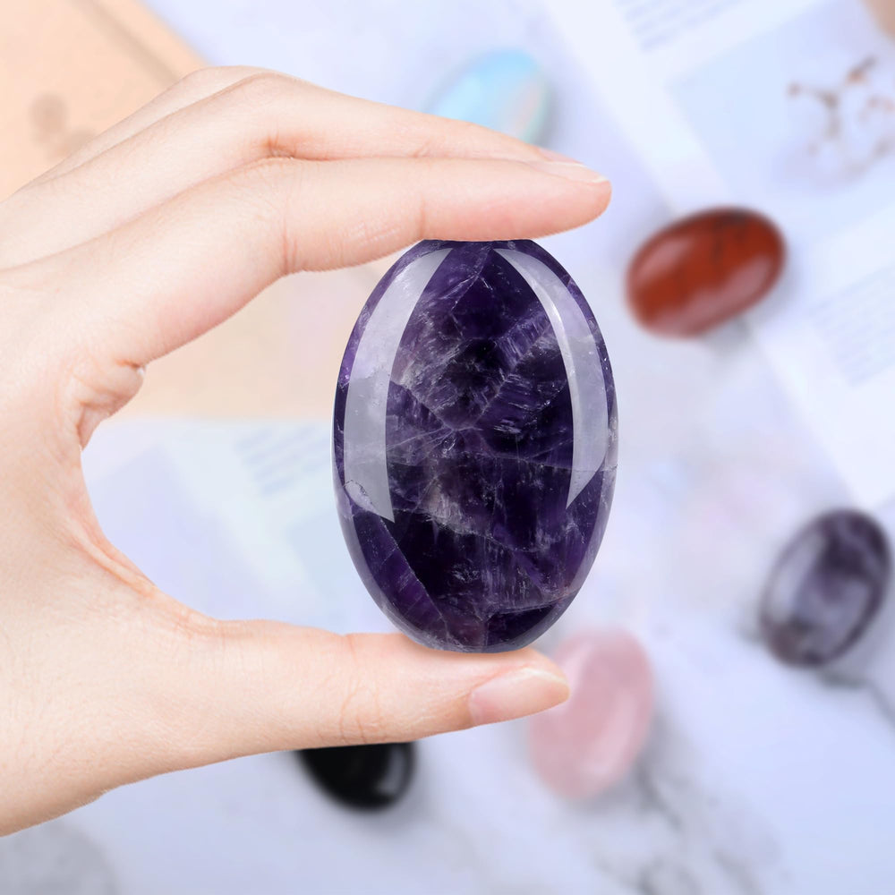 QINJIEJIE amethyst palm stone in hand for stress relief on the go.