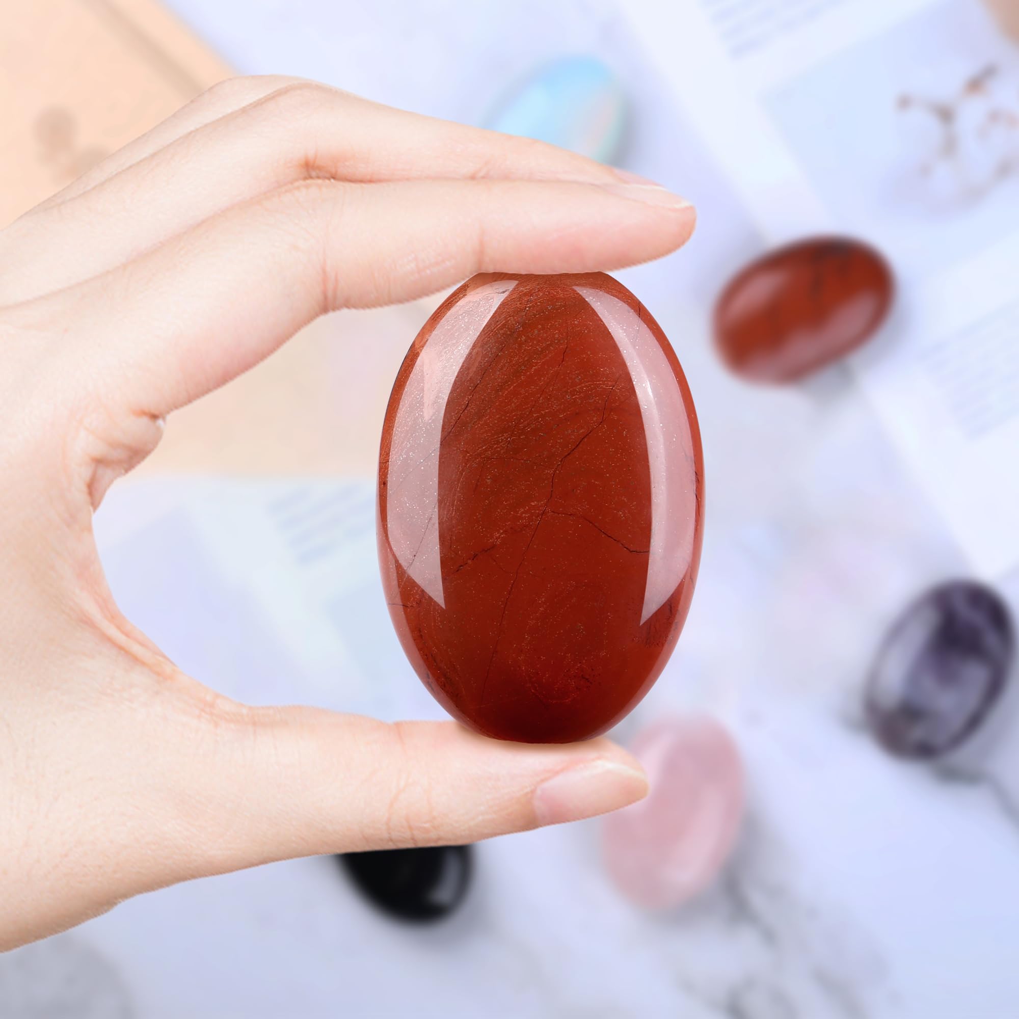 QINJIEJIE Red Jasper palm stone for desk decor and mindful focus.
