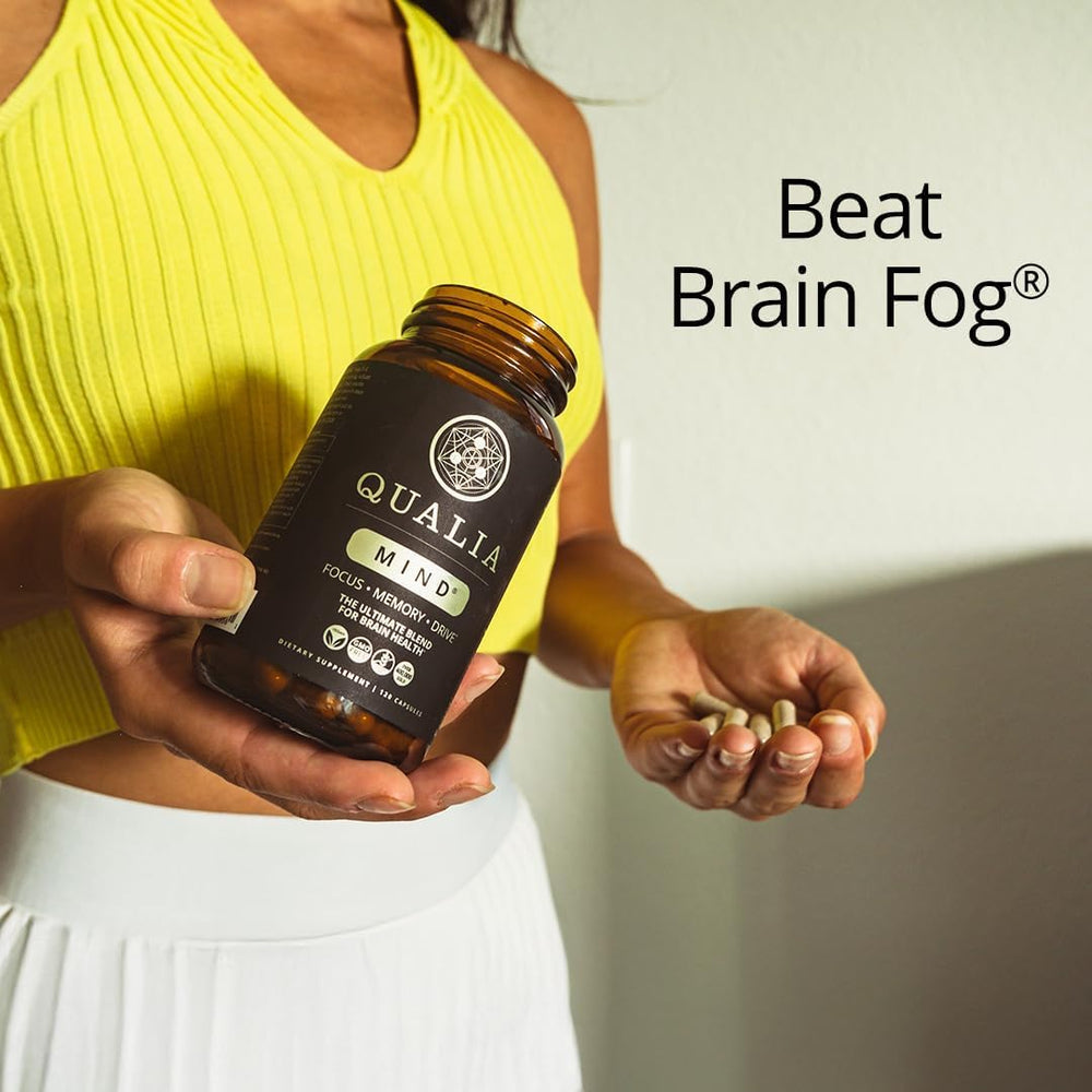 Qualia Mind bottle beside a glass of water during morning routine.