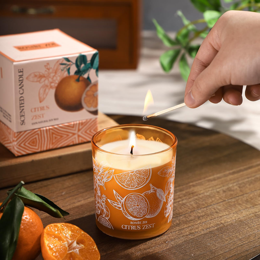 ROMIIE ZOI candle at dusk emits cozy citrus glow.