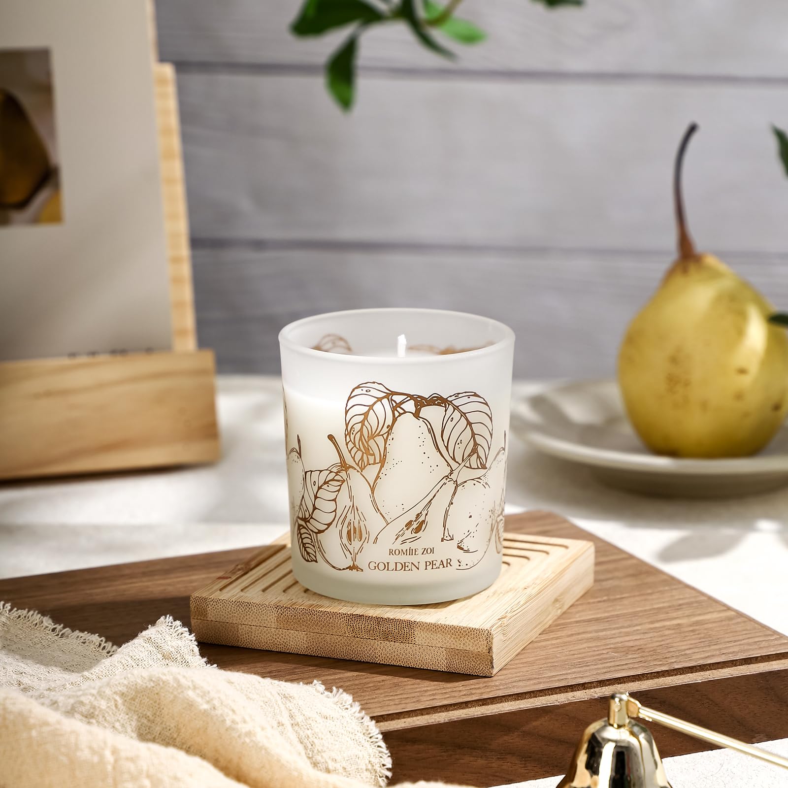 ROMIIE ZOI scented candle on bedside table creates a warm atmosphere.