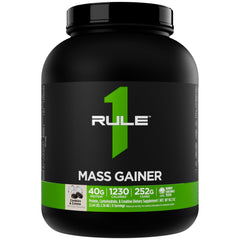 Rule1 Mass Gainer being poured into a shaker for a calorie-dense shake.