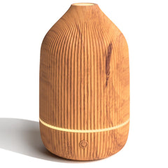 Salubrito essential oil diffuser with wood grain on desk delivers subtle ambient aroma.