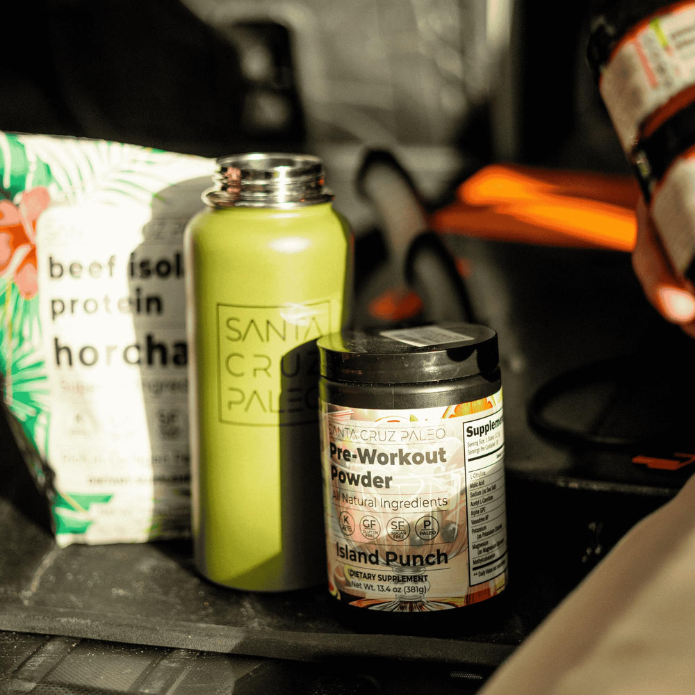 Santa Cruz Paleo Island Punch bottle on gym floor beside a water bottle