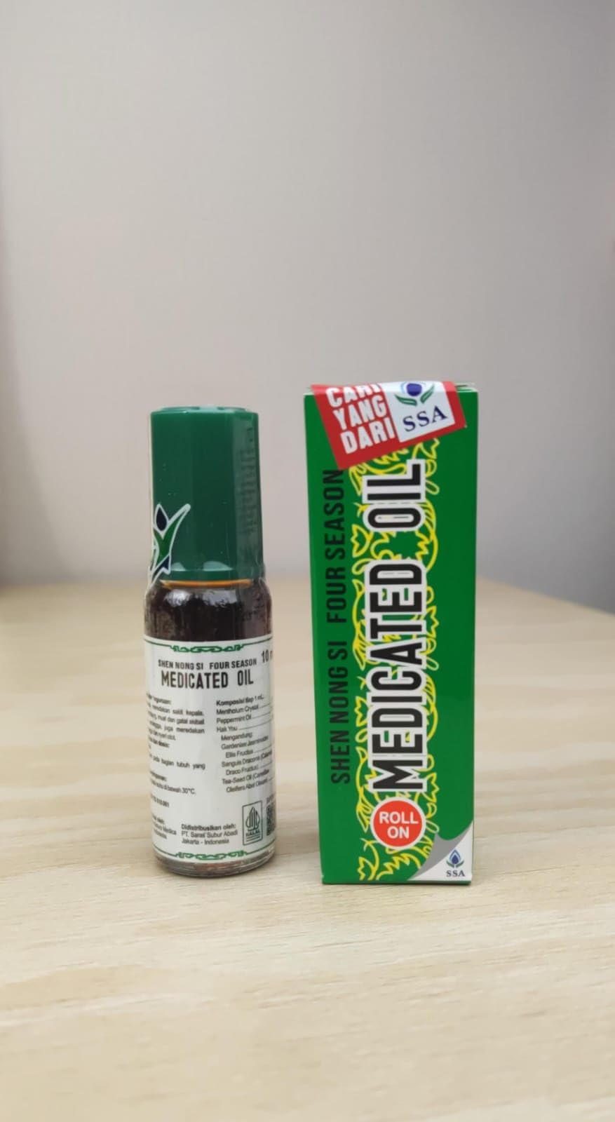 Compact travel bottle of Shen Nong Si Four Season oil ready for quick relief.