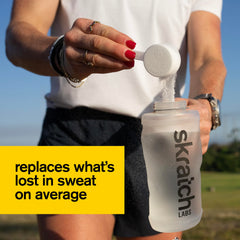 Athlete mixing Skratch Labs Hydration Powder in a bottle for steady energy during training.