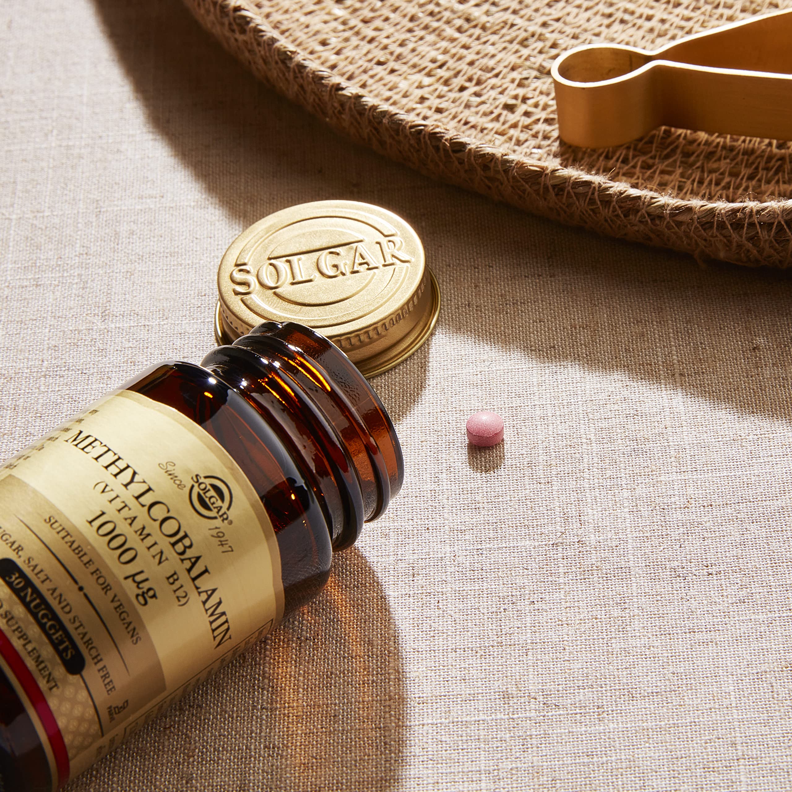 Solgar Methylcobalamin 1000 mcg Nuggets on table with glass of water for easy swallowing.