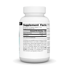 Dosing spoon beside Source Naturals Coral Calcium Powder bottle for precise measurement.