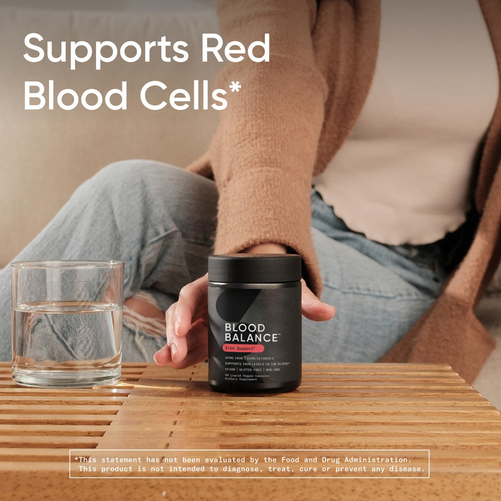 Sports Research Blood Balance bottle on a desk with a glass of water for routine use