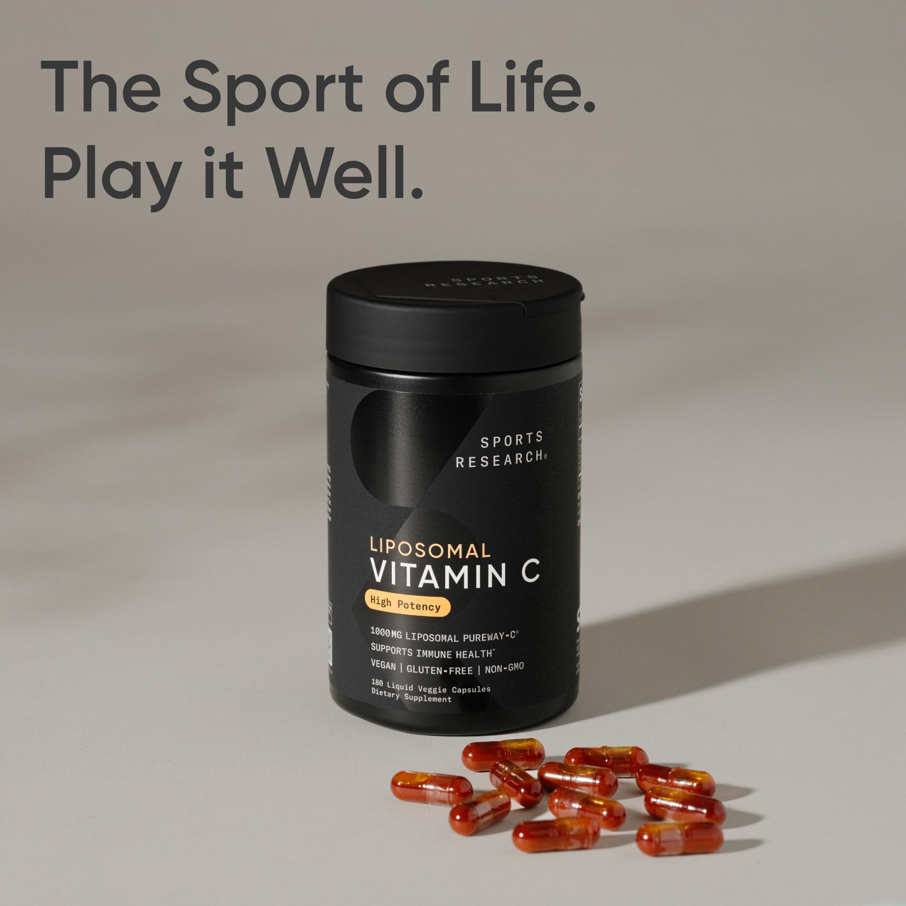 Sports Research liposomal vitamin C beside a glass of water for daily intake.