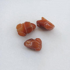 Sunshcat hand carved frog gemstone emphasizing unique grain and petite size.