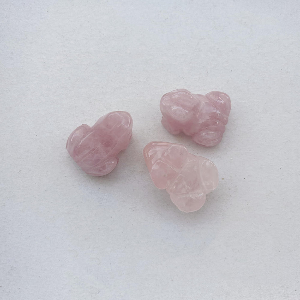 Sunshcat rose quartz frog held in hand for portable serenity and focus.