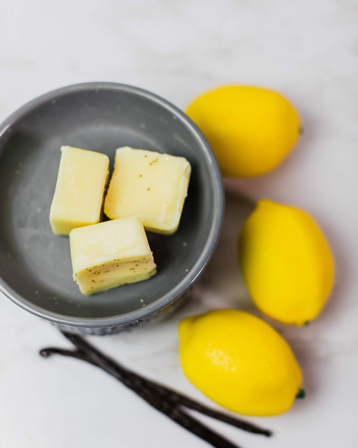 Swan Creek Luscious Lemon Vanilla Drizzle Melts beside a tea light for controlled diffusion