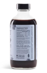Pouring Sweet's Elderberry syrup into a glass, smooth and tasty.