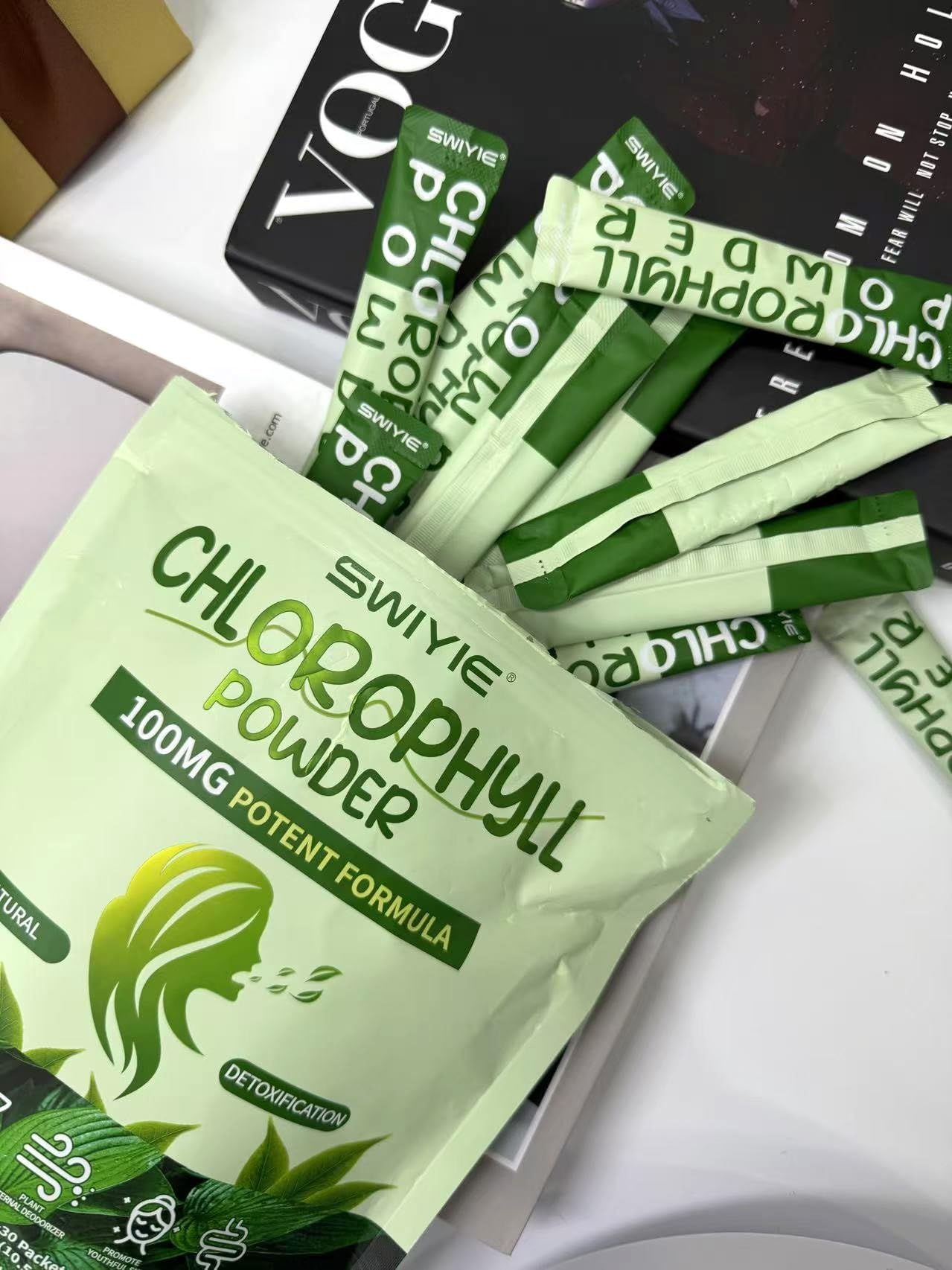 Pouring Swiyie chlorophyll powder into a glass for a fresh breath-friendly drink.