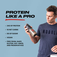 Scoop resting in a glass of TB12 protein shake