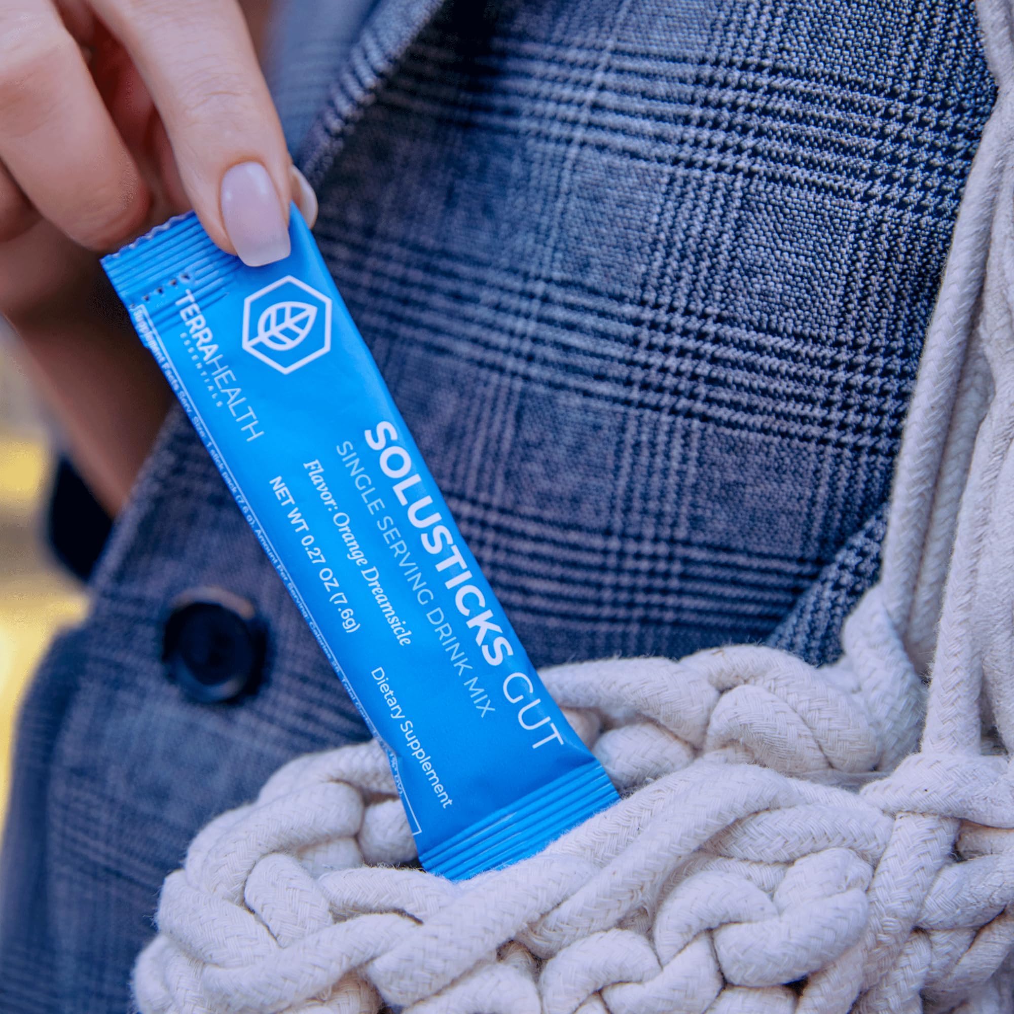 Terra Health Essentials Solusticks Gut orange sachet bathed in light represents fast mixability and flavor.