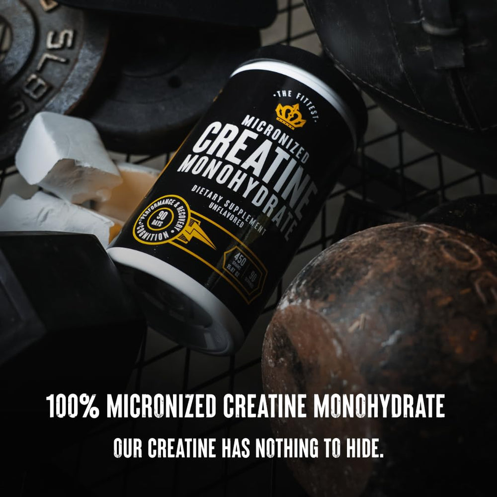 The Fittest Ever creatine powder beside a glass and scoop