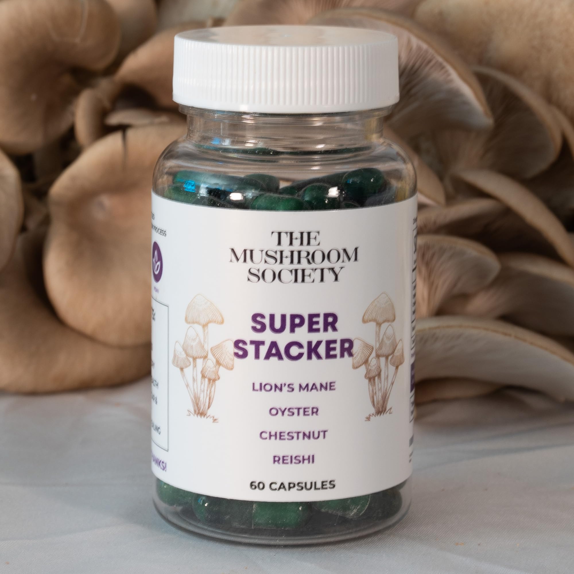 The Mushroom Society Super Stacker bottle on wood table with vegan capsules ready to take.