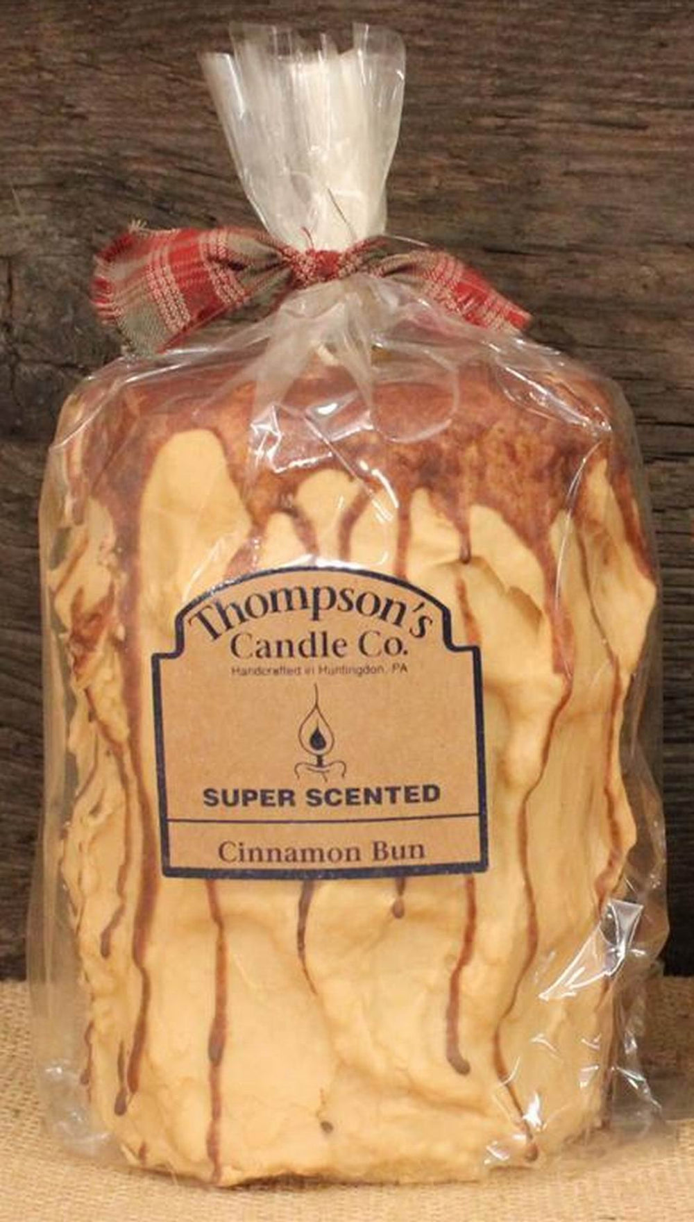 Thompson's Candle Co Super Scented LG Cinnamon Bun pillar candle glowing with warm aroma
