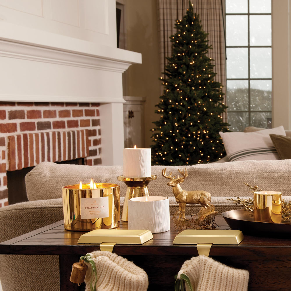 Thymes Frasier Fir candle with a 24k gold rim adds luxurious decor appeal.