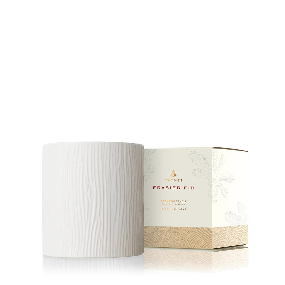 Thymes Frasier Fir candle in a wood-grain ceramic jar for a cozy winter ambiance.