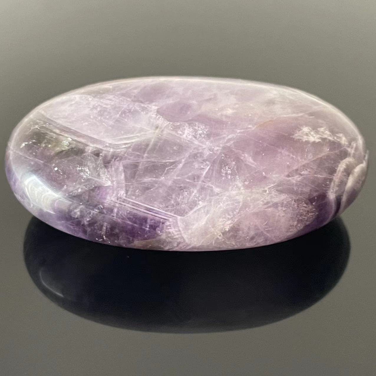 Truewon Amethyst palm stone oval in hand for grounding during focus sessions