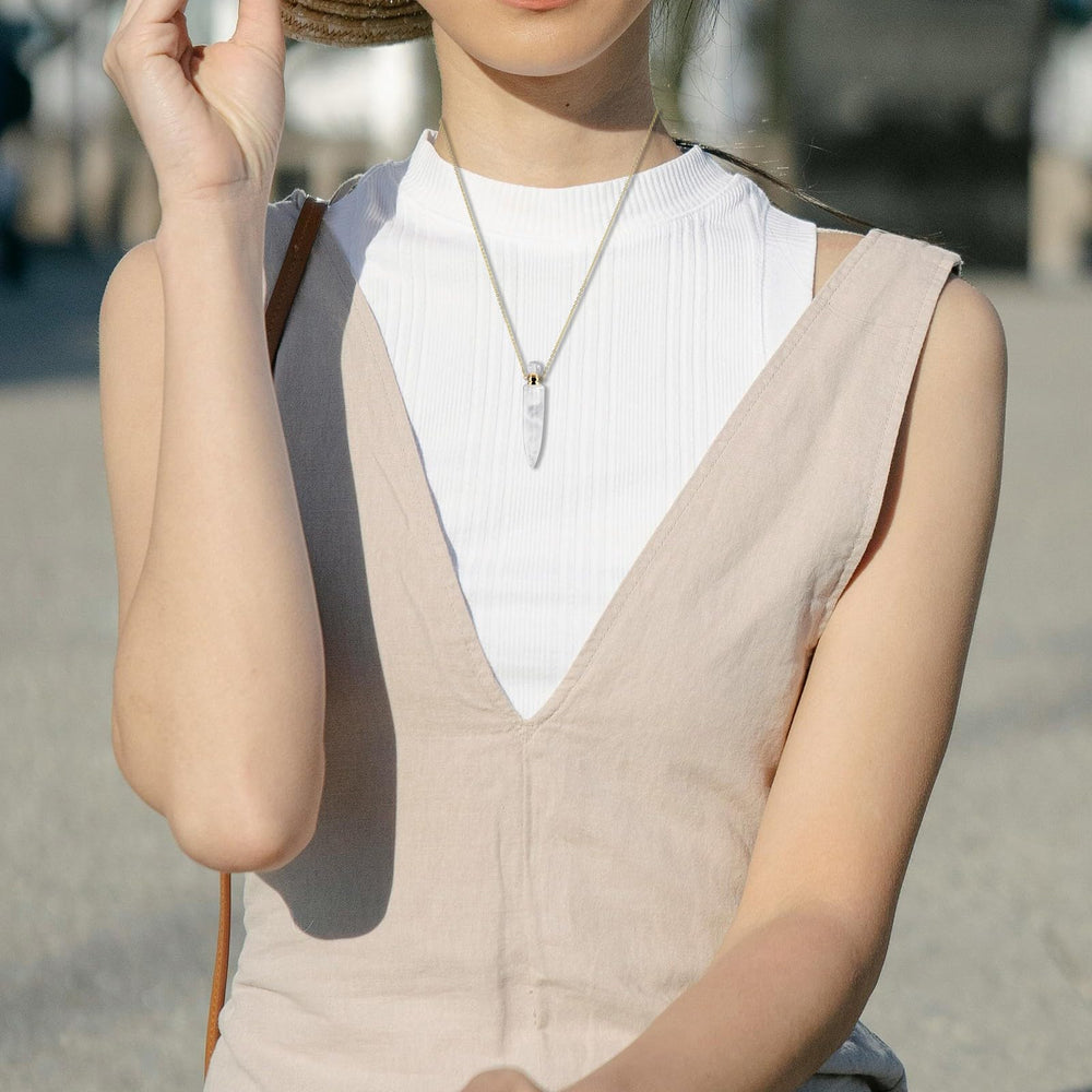TUMBEELLUWA diffuser pendant on gold chain worn casually, adding elegant touch to outfits.
