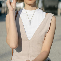 TUMBEELLUWA diffuser pendant on gold chain worn casually, adding elegant touch to outfits.