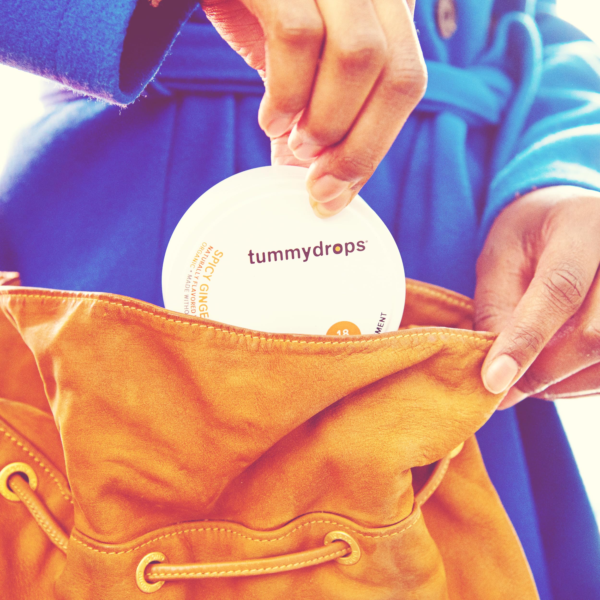 Tummy Drops ginger lozenges ready for daily routine beside a glass of water.