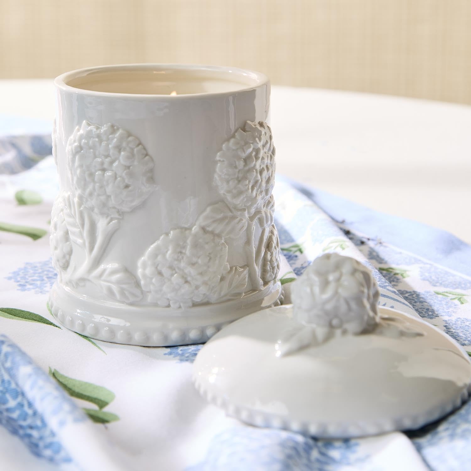 Close-up of hydrangea relief detailing on porcelain candle adds texture and sophistication.