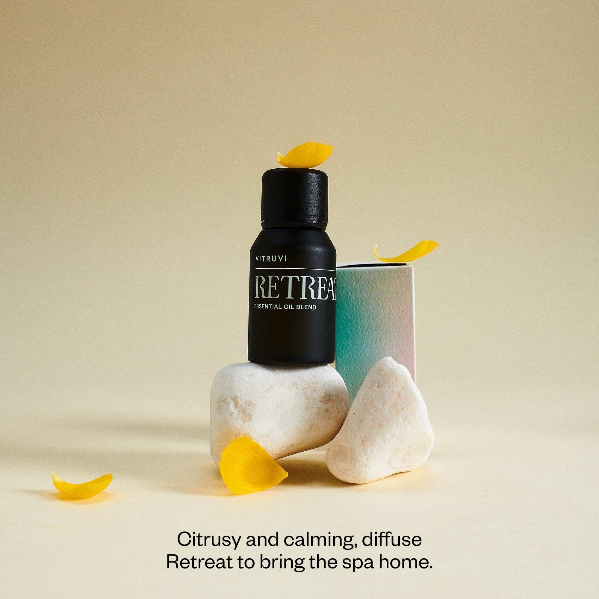 Bottle of Vitruvi Retreat with drops showing grapefruit and eucalyptus notes